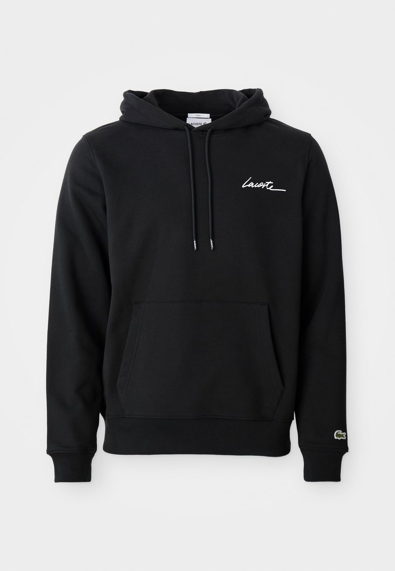 Sweat à capuche noir avec poche kangourou à l'avant, capuche réglable avec cordon, signature blanche "Lacoste" sur la poitrine et petit logo crocodile vert sur le bord de la manche.