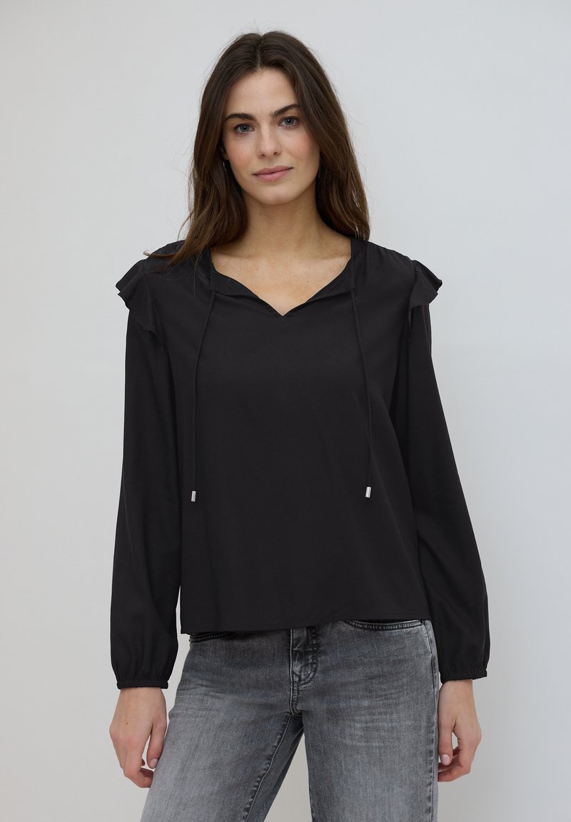 Blouse noire à col en V, avec des détails froncés sur les épaules et des liens à cordon. Dotée de manches longues et d'une coupe décontractée.