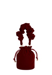 Red velvet drawstring bag with a gathered top and scrunched handles. Features gold hardware accents and smooth, soft texture.