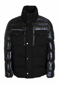Zwarte pufferjas met glanzende accenten, voorzien van een hoge kraag, twee borstzakken en drukknopsluiting. Zachte, gewatteerde textuur.