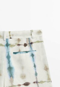 Pantalon en lin de couleur claire avec un motif tie-dye multicolore, doté d'une poche arrière unique et d'une coupe droite à l'avant.