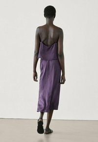 Lila Satin-Midikleid mit lockerer Passform, Spaghettiträgern und einem geschichteten Rücken. Verfügt über einen geraden Saum und eine glatte Textur.