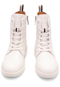 Zapatillas altas de cuero blanco con cordones, cremalleras laterales y tiradores a rayas en contraste. Textura suave con un diseño limpio.