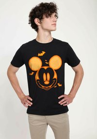 Svart bomullst-shirt med en orange Mickey Mouse-grafik med fladdermöss. Rund halsdesign, korta ärmar och figurnära passform.