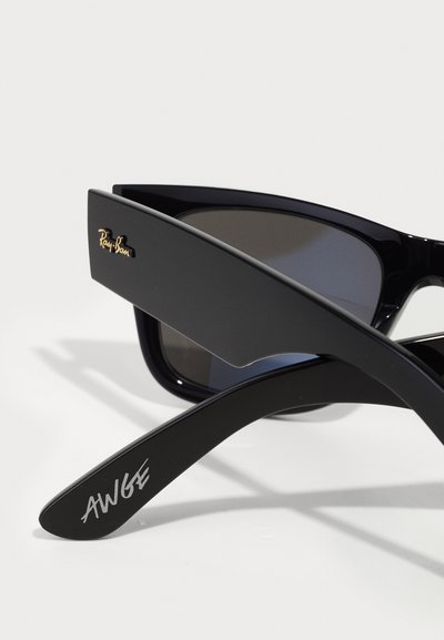 Черен модел слънчеви очила Ray-Ban с тъмни стъкла, с елегантен дизайн, минимална текстура и гравиран подпис "AWGE" на страната.