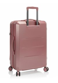 Hartschalentrolley in Pink mit strukturierten Oberflächen, zwei Inline-Rädern, einem ausziehbaren Griff und einem seitlichen Tragegriff. Verfügt über horizontale Rillen.