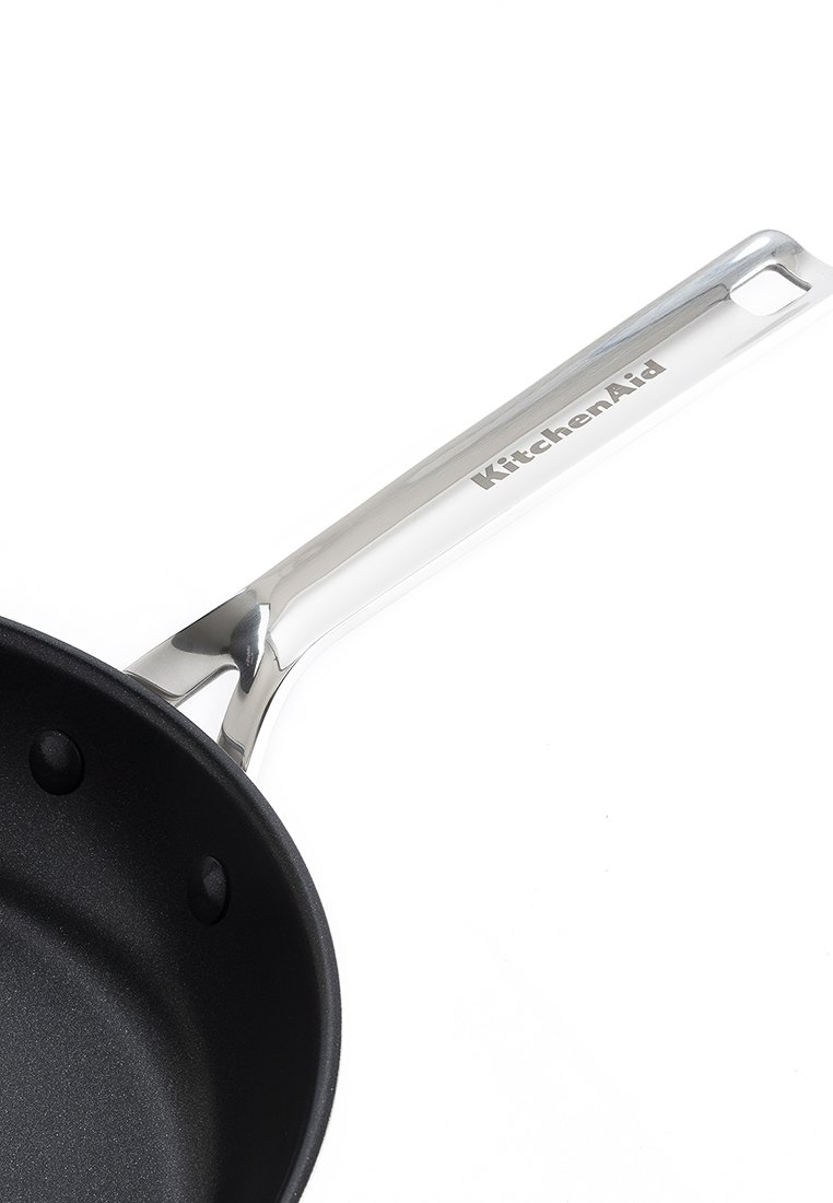 Czarny rondel z powłoką nieprzywierającą i stalowym uchwytem, z gładką powierzchnią oraz logo marki KitchenAid wzdłuż uchwytu.