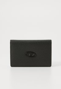 Black textured leather cardholder with a smooth oval logo accent on the front. Compact rectangular shape, clean lines, and minimalistic design.