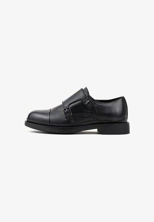 Czarne skórzane buty typu monk strap z podwójnymi klamrami, gładką teksturą, okrągłym czubkiem i lekko podniesioną czarną gumową podeszwą.