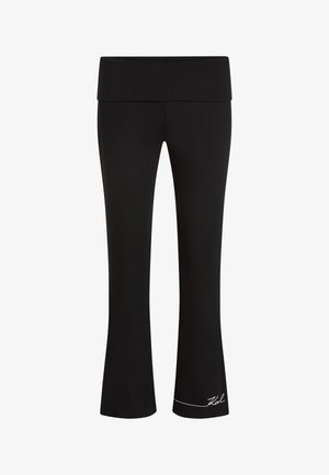 Mustad lehvitatud joogapüksid laiade vöökohaga, soonilise tekstuuriga ja valge logoga ääre lähedal. Kujundatud mugavuse ja paindlikkuse tagamiseks.