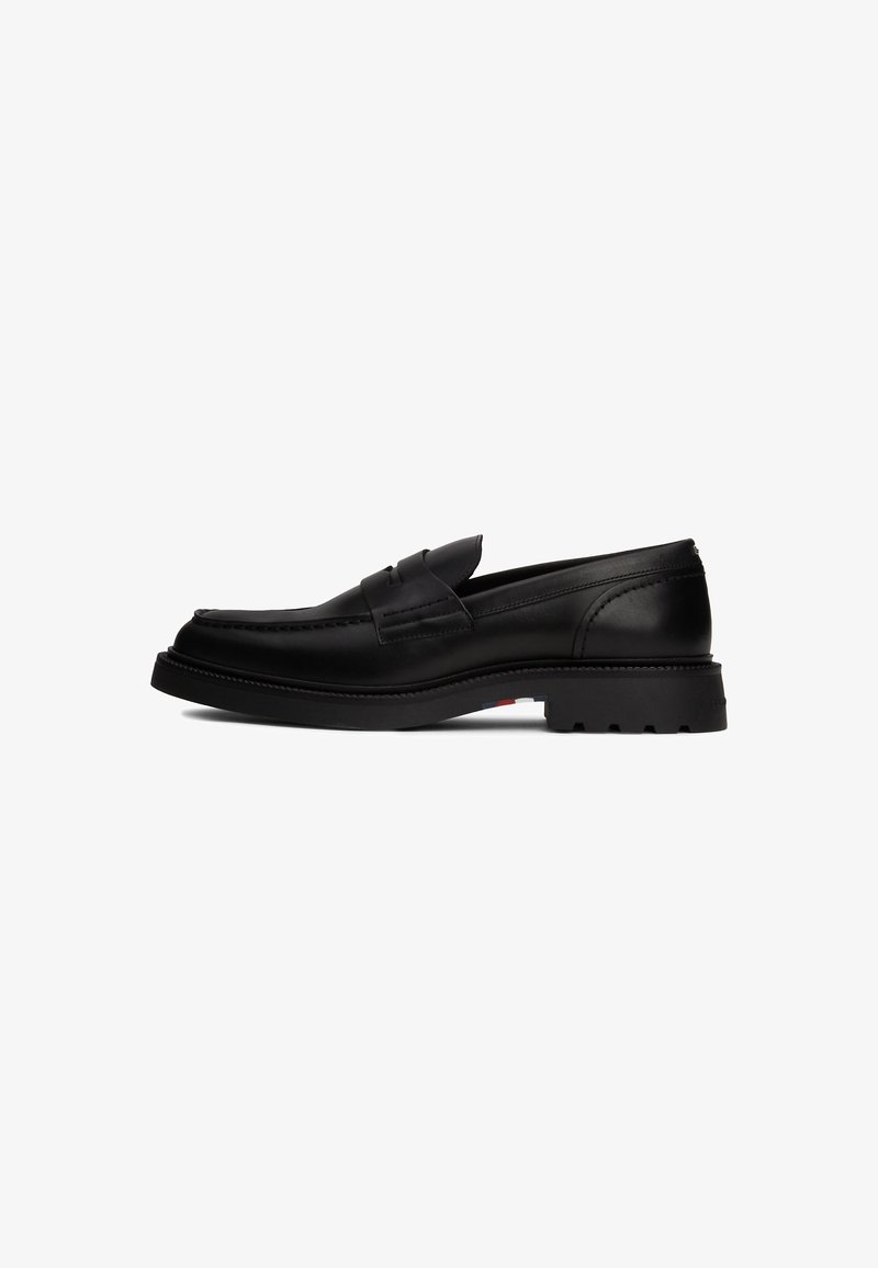Mocassin en cuir noir avec une semelle épaisse crantée, détail de bride penny et un subtil accent tricolore sur la semelle.