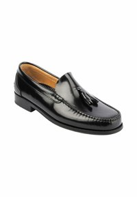Mocasines de cuero negro con un diseño cerrado, con costuras intrincadas y un borlas decorativa en la parte delantera. Textura suave y tacón bajo.