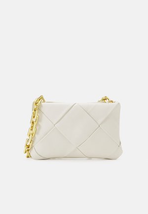 Pochette en cuir blanc doux tissé avec une grande chaîne dorée en bandoulière sur fond uni.