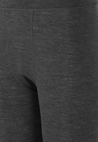 Grå leggings tillverkade av ett mjukt, texturerat tyg. Har en figurnära design med hög midja och minimala sömnadsdetaljer.