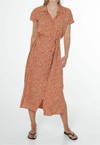 Rustonsävyinen midi-mekko, jossa on kukkakuosi, lyhyet hihat, napitettava etuosa ja vyötäröllä solmittava vyö. Kevyt kangas laskeutuu pehmeästi.