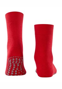 Calcetines tobilleros rojos con elástico en el puño, textura suave y puntos de agarre de silicona en las suelas para mayor tracción. Disponibles desde dos perspectivas anguladas.