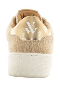 Baskets beige avec une tige texturée ressemblant à de la laine, une languette de talon en métal doré, une semelle en caoutchouc blanc et un logo en relief sur le talon.