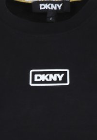 Zwarte katoenen t-shirt met een witte rechthoekige DKNY-logo op de voorkant. Ronde halslijn met een gladde textuur en een eenvoudig ontwerp.