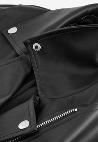 Zwarte leren jas met een gladde textuur, zilveren drukknoopsluiting en een metalen rits met tanddetail. Close-up van de kraagsectie.