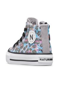 Baskets montantes avec un imprimé léopard pailleté multicolore, lacets noirs, semelle blanche et une étiquette ronde avec un logo sur le côté.