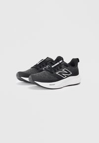 Des chaussures de sport noires avec une tige en tissu texturé, des accents blancs et une semelle rembourrée portant l'inscription "FRESH FOAM". Présente un design traditionnel à lacets.
