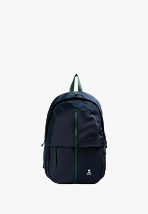 Sac à dos bleu marine avec une texture lisse, présentant une grande poche avant, des accents verts et un logo de skull en bas. Bretelles vertes ajustables.