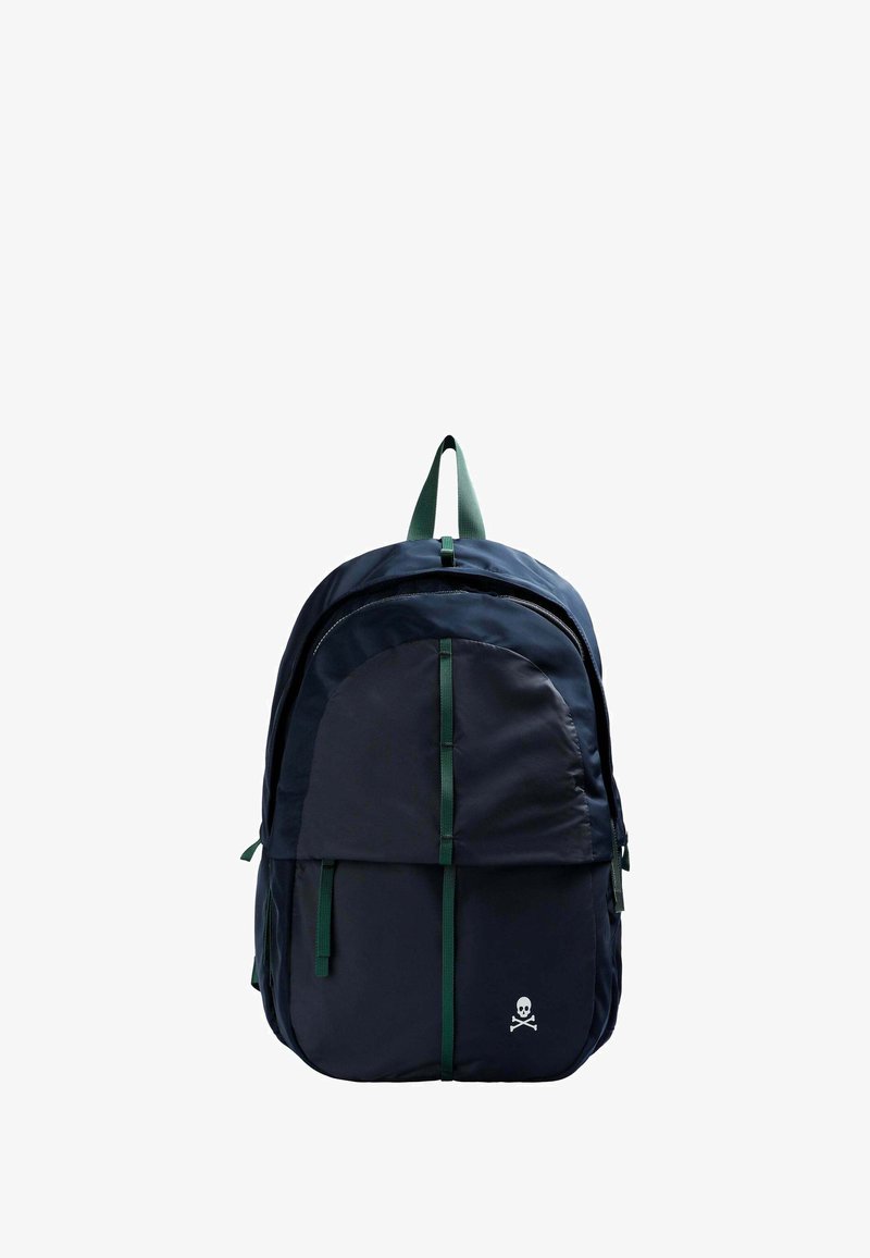 Mochila azul marino con una textura suave, que cuenta con un gran bolsillo frontal, acentos verdes y un logo de calavera en la parte inferior. Correas verdes ajustables.