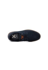 Zapato de ante azul oscuro con punta redondeada, diseño con cordones, acento en cuero marrón y suela texturizada. Presenta una plantilla con marca.