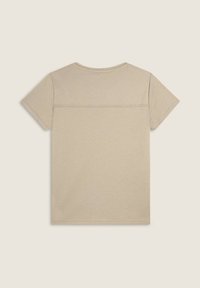 Camiseta corta de manga corta color beige hecha de algodón. Presenta un cuello redondo y un detalle de costura horizontal en la parte posterior. Textura suave.