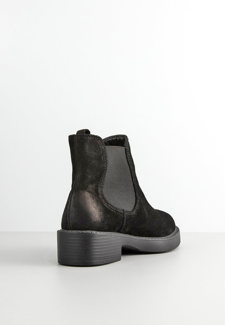 Botín negro de ante hasta el tobillo con paneles laterales elásticos, punta redondeada y tacón bajo apilado, con un acabado texturizado y diseño simple.
