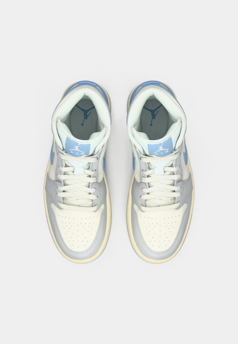 Une paire de baskets Nike Air Jordan légères bleues et blanches montrées de dessus sur un fond blanc uni.