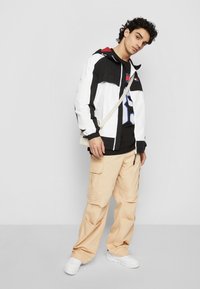 Tommy Jeans CHICAGO UNISEX - Allvädersjacka - black/deep crimson/white