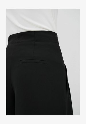 Black tailored pants featuring a smooth fabric, slim silhouette, and a flat back pocket. The waistband is neatly finished.