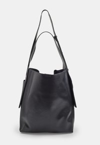 Borsa a tracolla in pelle nera con una texture morbida, apertura ampia, lungo manico a spalla e tasche laterali. Design minimalista senza hardware visibile.