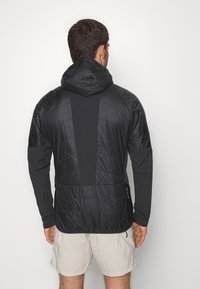 Must must vest, millektitudega, sisaldab kindlat kangast seljatükki ja küljetaskuid. Kerge ja sportlik sobivuse disain.