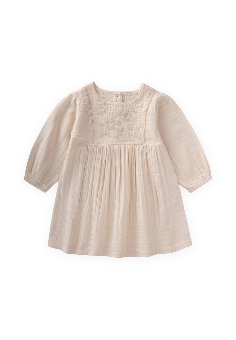 Šviesiai ruda medvilnės suknelė su ilgomis rankovėmis, papuošta siuvinėtais gėlių motyvais prie liemens ir minkšta, plisuota sijonu.