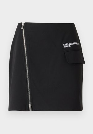 Černá mini sukně s bočním zipem a detaily kapsy. Vyrobena z hladkého materiálu s vyšitým logem na přední straně.