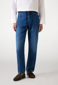 Blue denim trousers with an elastic waist, drawstring, front pockets, and a relaxed fit. Smooth texture and straight-leg design.