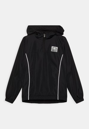 Chaqueta cortavientos negra con cuello con cremallera, puños elásticos y franjas blancas laterales. Presenta un pequeño logo en la zona del pecho. Material ligero.