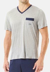 Camiseta gris de cuello en V hecha de una tela ligera. Presenta acentos en navy en el escote y el bolsillo. Incluye un pequeño logotipo en el bolsillo del pecho.