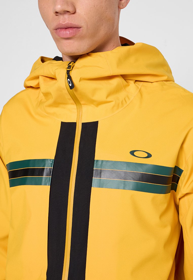 Giacca gialla con zip e cappuccio neri, strisce nere e teal sul petto e un logo sul lato sinistro. Texture liscia.