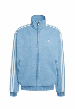 Veste zippée Adidas en denim bleu clair avec col haut, trois bandes blanches sur les manches, poignets élastiques et poches avant zippées.