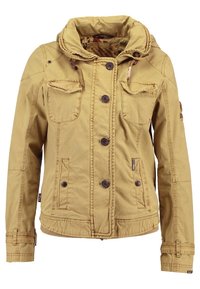 Beige jacka med huva, gjord av mjukt material. Har sex fickor och knappstängning fram. Slät textur med en lätt glans.