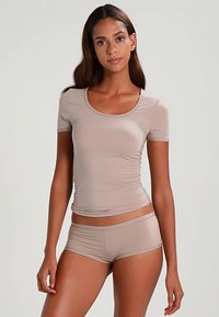 Beige tætsiddende kortærmet top med rund halsudskæring kombineret med matchende shorts. Glat tekstur og elastisk stof for komfort.