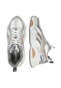 Vīriešu sporta apavi ar pelēku, baltu un zelta akcentu kombināciju. Aizsargājoša acs augšdaļa ar mīkstinātu apkakli un teksturētu gumijas zoli, kas nodrošina saķeri.