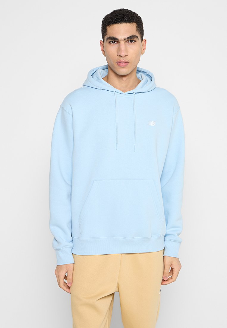 Haut à capuche bleu clair en tissu doux, avec une poche kangourou, un cordon de serrage pour la capuche et un petit logo blanc sur la poitrine.