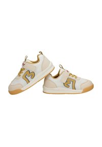 Paire de baskets pour enfants beige et blanches avec des accents jaunes, des bandes Velcro et des semelles en caoutchouc, présentées sur fond blanc.
