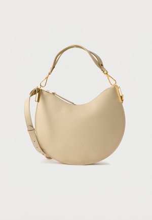 Bolso de hombro de cuero beige con diseño curvo, herrajes dorados, correa ajustable y textura suave. Cuenta con cremallera superior.
