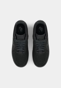 Sapatilhas Nike Air pretas com material texturizado, bico redondo, atacadores planos e colarinho acolchoado. Apresenta o logotipo na palmilha e detalhes sutis.