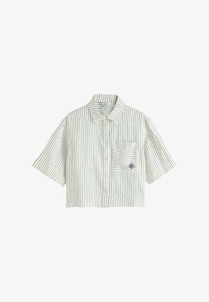 Chemise blanche à manches courtes avec des rayures verticales fines noires et une poche avant brodée d'un petit motif de boussole.